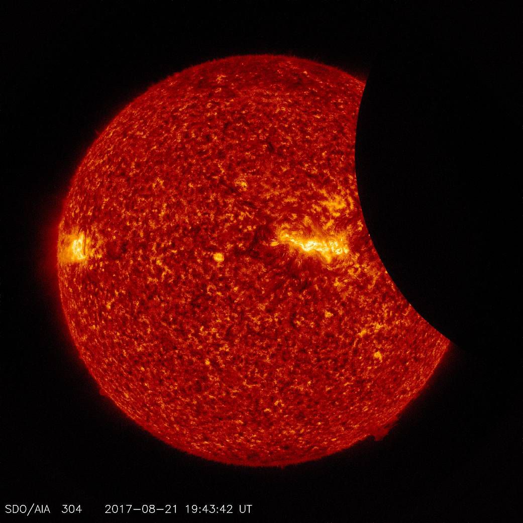 Image of the Moon transiting across the Sun, taken by SDO in 304 angstrom extreme ultraviolet light